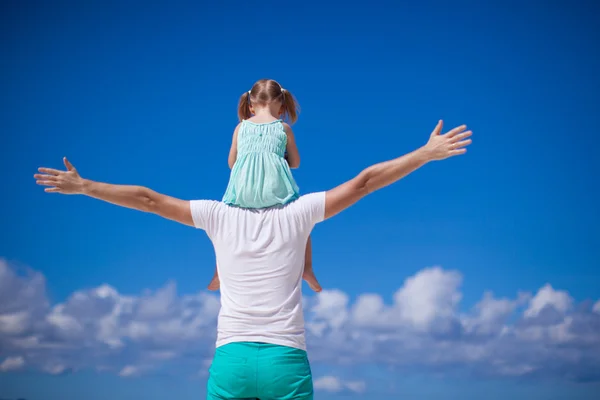 Back view of little girl hugging with dad on the beach — Stock Photo, Image