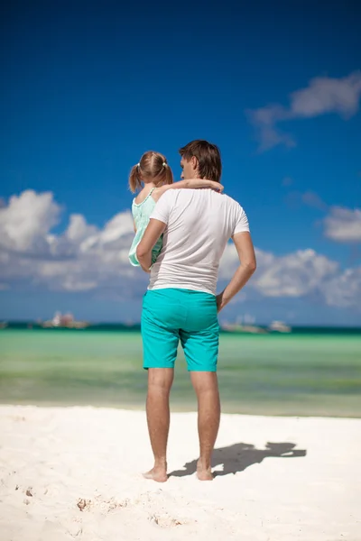 后视图与爸爸在海滩上抱着的小女孩 — 图库照片
