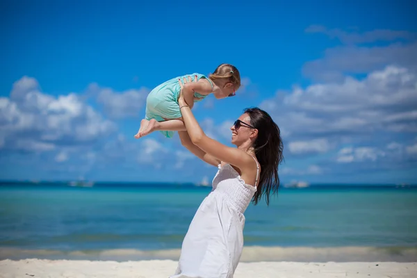 युवा सुंदर माँ और उसकी प्यारी छोटी बेटी उष्णकटिबंधीय समुद्र तट पर मज़ा है — स्टॉक फ़ोटो, इमेज