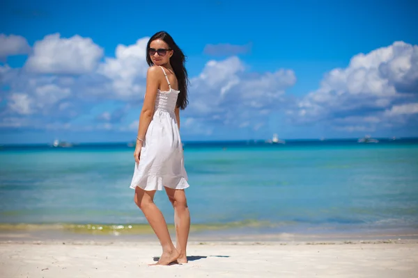 Mujer joven en vestido blanco disfrutar de las vacaciones en la playa — Foto de Stock