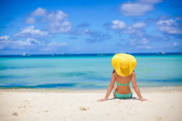 Beautiful back side of model in bikini and hat sitting down. — Stock Photo, Image