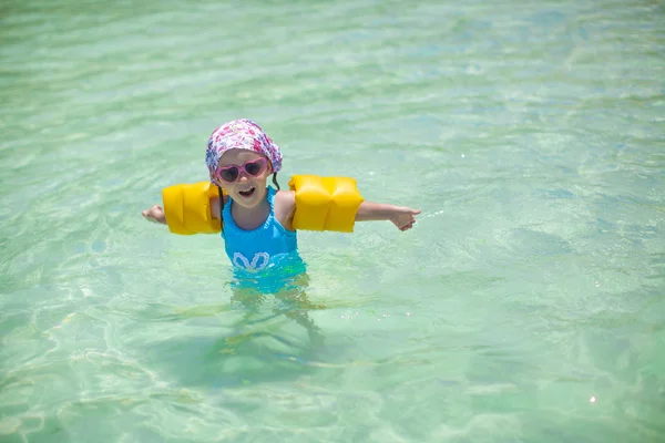 Kleines süßes glückliches Mädchen im Badeanzug hat Spaß im Meer — Stockfoto