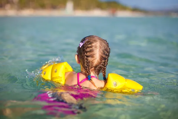 Adorable little girl swimming in the sea on tropical beach vacation — Stock Photo, Image