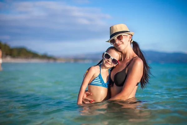 Mladá krásná matka a její rozkošná dceruška na pláži — Stock fotografie