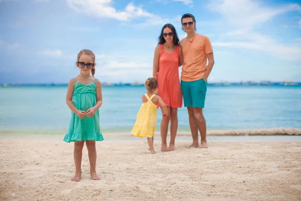 Junge schöne Familie mit zwei Töchtern hat Spaß am Strand — Stockfoto