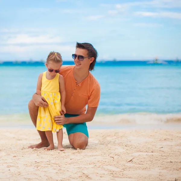 Happy father and his adorable little daughter on white sand — Stock Photo, Image