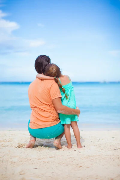 Bakifrån av unga far och hans bedårande lilla dotter ha kul på stranden — Stockfoto