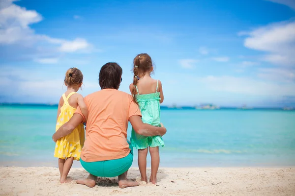 Back view of happy father with his two daughters on tropical beach vacation — Stock Photo, Image