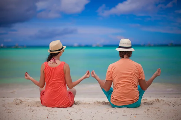 Jong koppel genieten van elkaar en yoga op een strand — Stockfoto