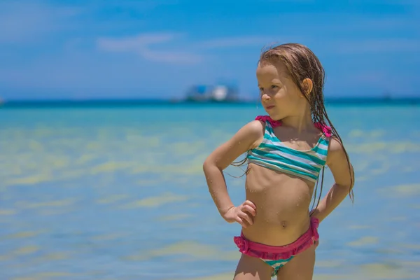 Vacker liten flicka stående i vattnet vid stranden — Stockfoto