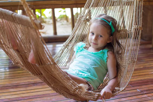 Schattig meisje in een hangmat op het terras van haar huis — Stockfoto