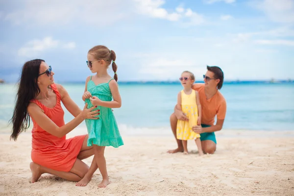 Mama mit ihrer älteren Tochter im Vordergrund und Papa mit der jüngsten Tochter im Hintergrund am Strand — Stockfoto