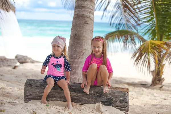 Dos hermanas pequeñas con bonitos trajes de baño se divierten en la playa tropical de Tulum, México —  Fotos de Stock