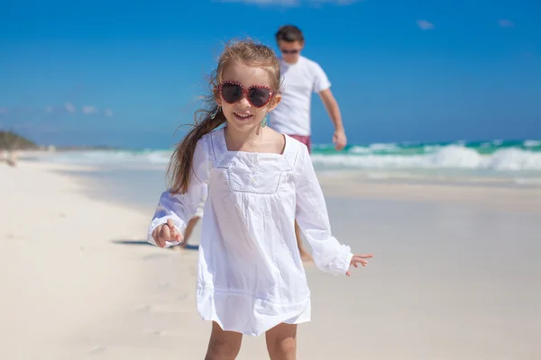 Portrait of adorable girl and his father with little sister in the background at tropical beach — Stock Photo, Image