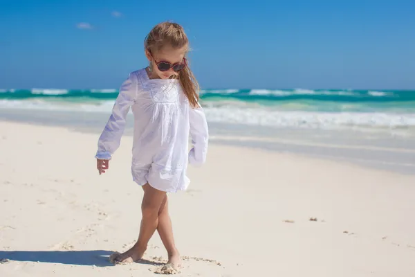 Adorable little girl in beautiful clothes dancing at tropical beach — Stock Photo, Image