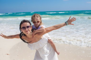 genç güzel anne ve tropik sahilde bir kuş gibi uçmak çok güzel küçük kızı