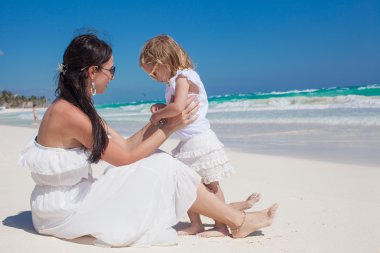 Anne ve küçük kızı arkadan görünüm keyfini çıkarın tatil tropikal plaj