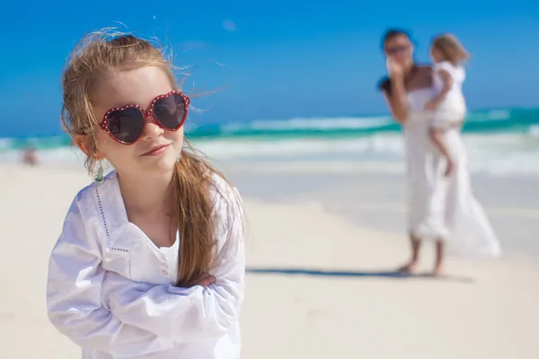 Portrait of funny girl and her mother with little sister in the background on summer vacation — Stock Photo, Image