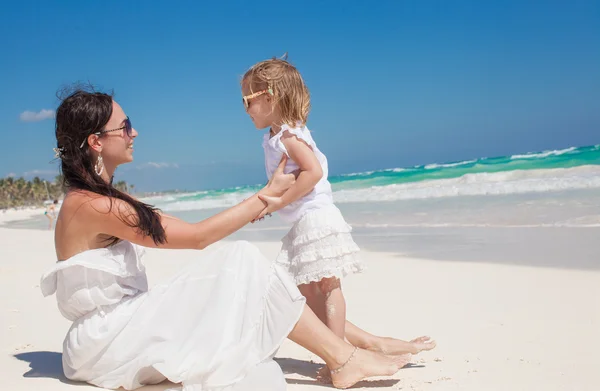 Jovem bela mãe e sua adorável filhinha na praia tropical — Fotografia de Stock