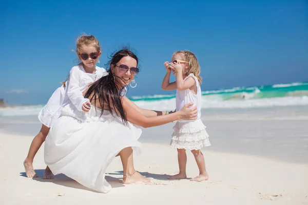 Young mother and two her fashion kids at exotic beach on sunny day — Stock Photo, Image