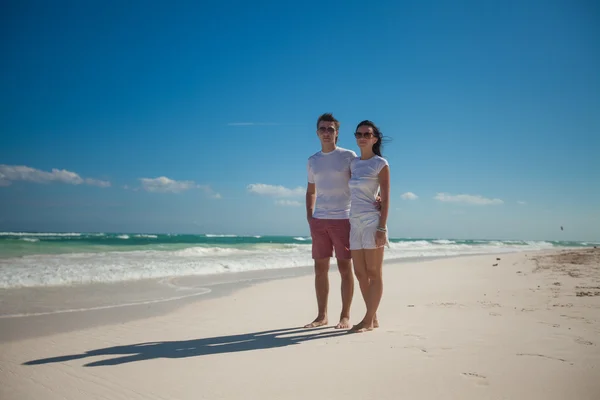 Unga romantiska par promenader på exotiska strand i solig dag — Stockfoto