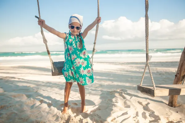 Menina adorável em um vestido e óculos de sol no balanço na praia de areia branca do Caribe — Fotografia de Stock