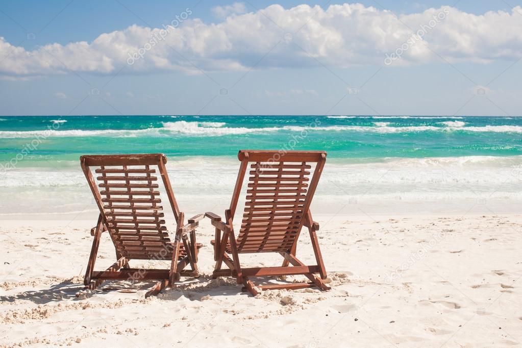 Beach wooden chairs for vacations and relax on tropical beach in Tulum, Mexico