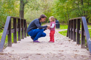 Genç baba küçük kızı sonbahar Park yürüyüş