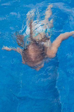 küçük şirin mutlu kız yüzme havuzunda yüzüyor