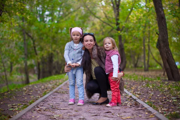 Joven madre con sus hijas pequeñas mirando a la cámara al aire libre —  Fotos de Stock