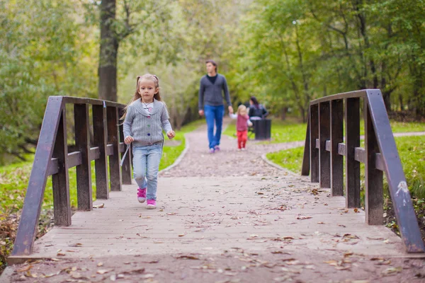 Чудесная маленькая девочка гуляет на свежем воздухе с отцом и сестрой — стоковое фото