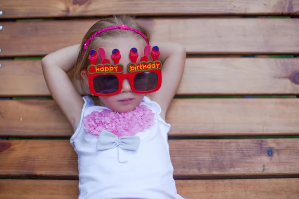 Schattig klein meisje in rood gelukkige verjaardag glazen — Stockfoto