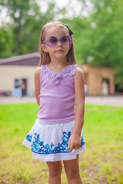 Wonderful little girl in sunglasses walking at summer park — Stock Photo, Image