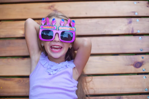 Adorable little girl in Happy Birthday glasses have fun outdoor — Stock Photo, Image