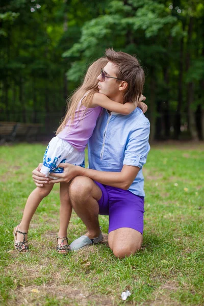 Ung pappa kramar hans lilla bedårande dotter utomhus — Stockfoto