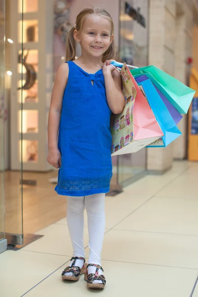 Cute fashion girl holding shopping bags and walking at the mall — Stock Photo, Image