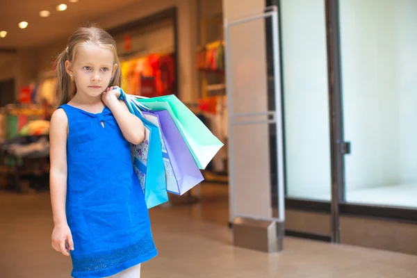 在商场举行购物袋的小时尚女孩的肖像 — 图库照片