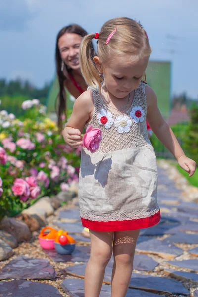 Joven madre con su linda hija divertirse en el jardín hora de verano —  Fotos de Stock