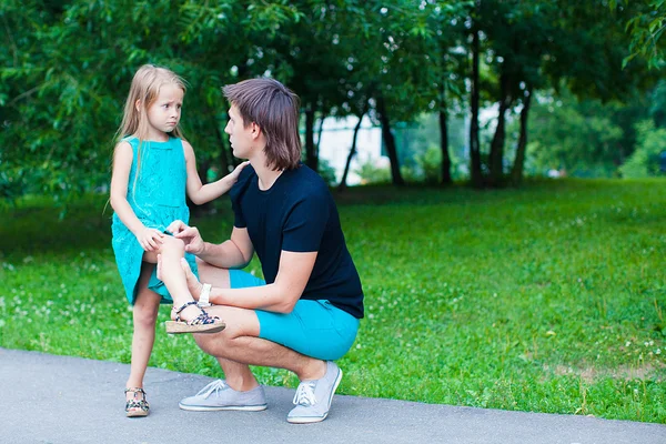 Young father pities his little daughter, who hurt her leg — Stock Photo, Image
