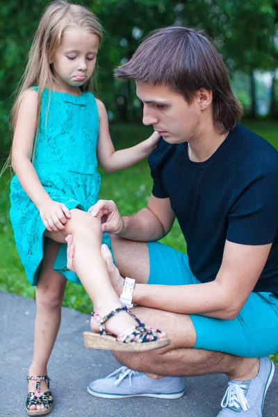 Young father pities his little daughter, who hurt her leg — Stock Photo, Image