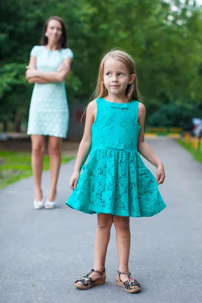 Closeup of little fashion girl on background of young beautiful mother — Stock Photo, Image