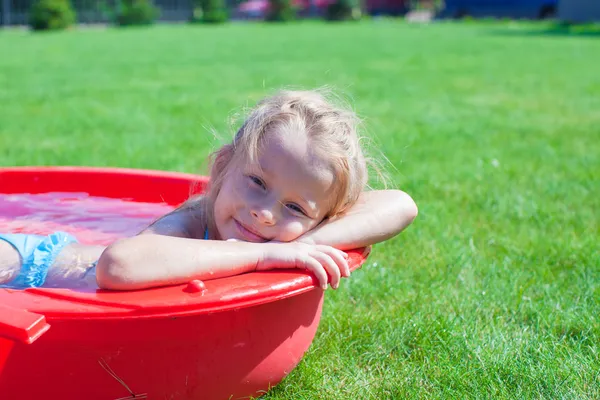 Charmig liten tjej njuter av sin semester i pool utomhus porträtt — Stockfoto