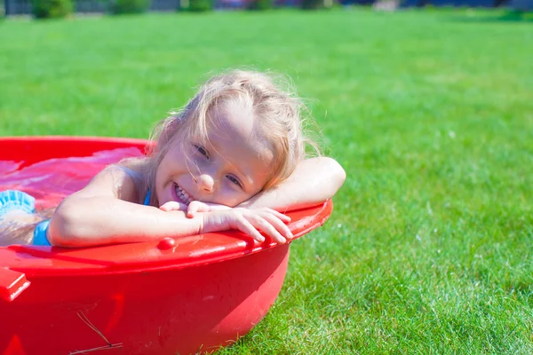 Porträtt av leende charmiga lilla tjejen njuter av sin semester i poolen utomhus — Stockfoto