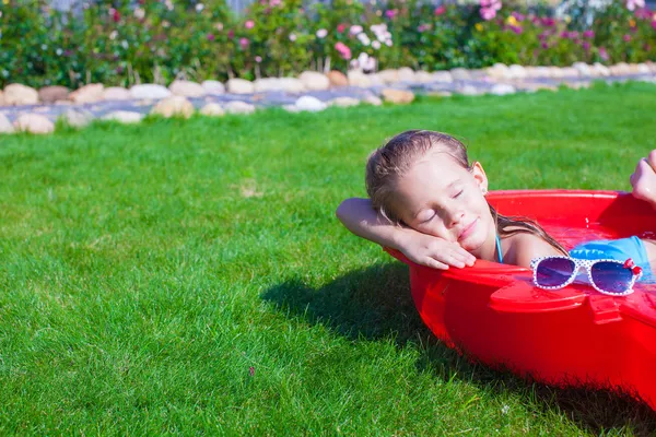 Ritratto di rilassante affascinante bambina godendo la sua vacanza in piccola piscina — Foto Stock