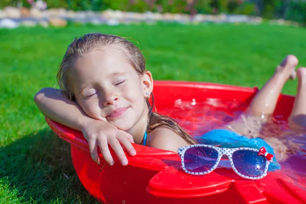 Okouzlující holčička užívat své dovolené v bazénu venku — Stock fotografie