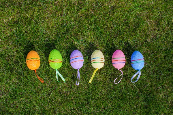Многоцветные пасхальные яйца на зеленой траве — стоковое фото
