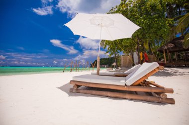 cennet görünümü güzel tropik boş kumlu Plage şemsiye ve plaj sandalyesi ile