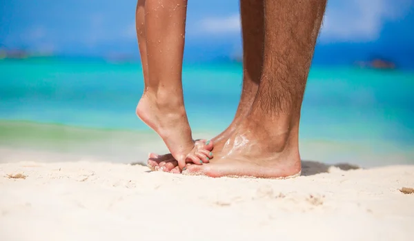 Niña de pie sobre los pies de su padre en la playa de arena blanca —  Fotos de Stock