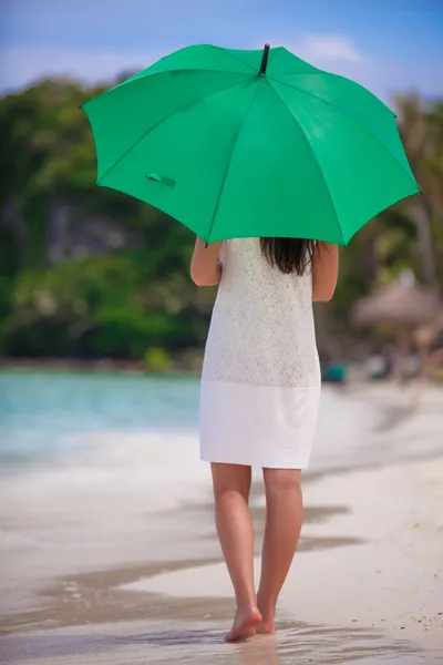 समुद्रकिनारावर हिरव्या छत्री असलेल्या तरुण स्त्रीचे मागे दृश्य — स्टॉक फोटो, इमेज