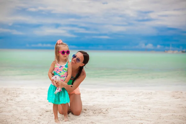 Młoda piękna matka i jej urocza córeczka bawią się na tropikalnej plaży — Zdjęcie stockowe
